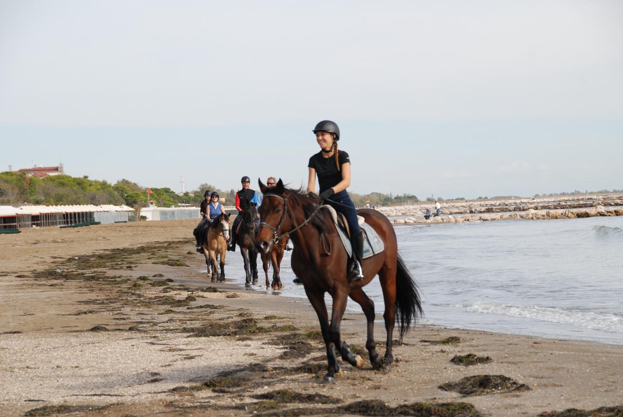 Cavalieri a passo sulla spiaggia del Lido, vicino al mare