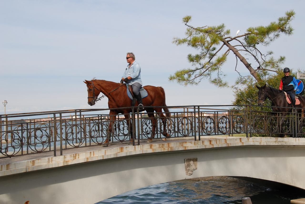 Cavalieri attraversano un ponte sul lungomare del Lido di Venezia